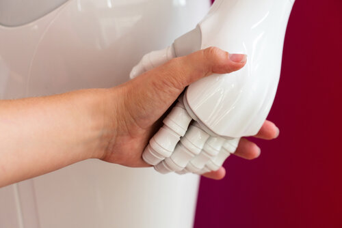 Menschliche Hand hält Roboterhand